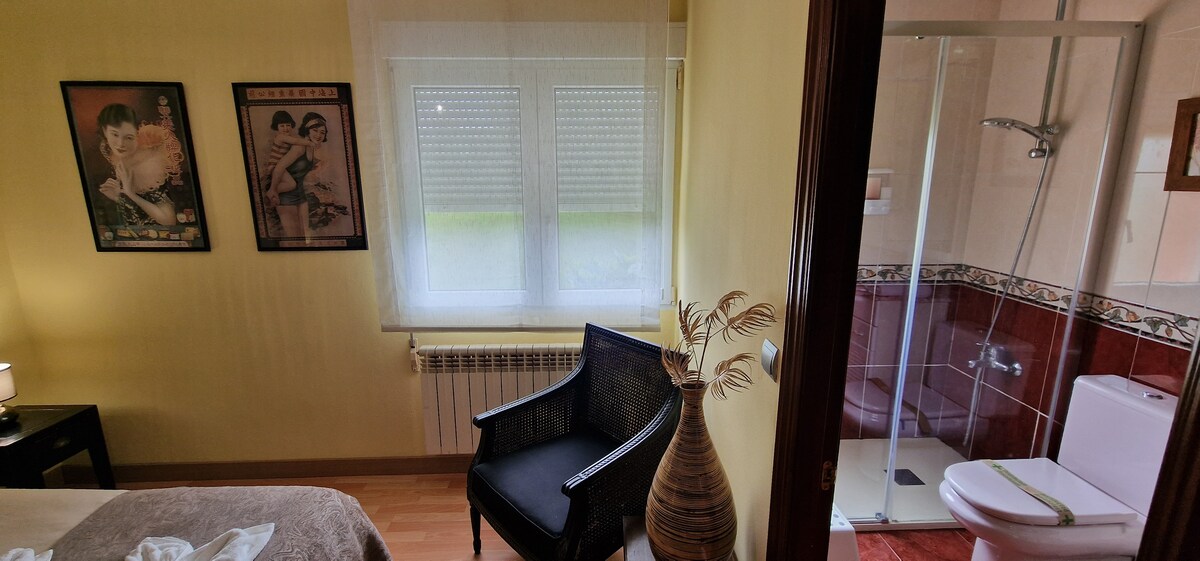 Dormitorio principal con baño y zona de descanso