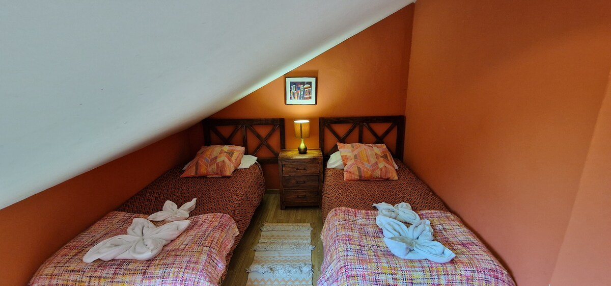 Dormitorio abuhardillado con dos camas individuales
