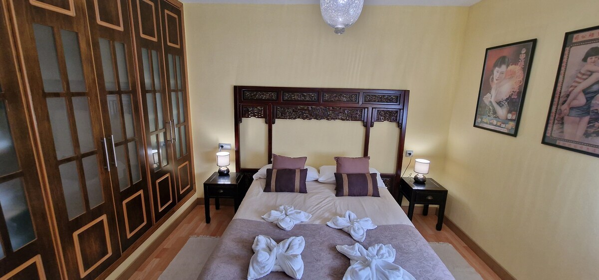 Dormitorio principal con baño y zona de descanso