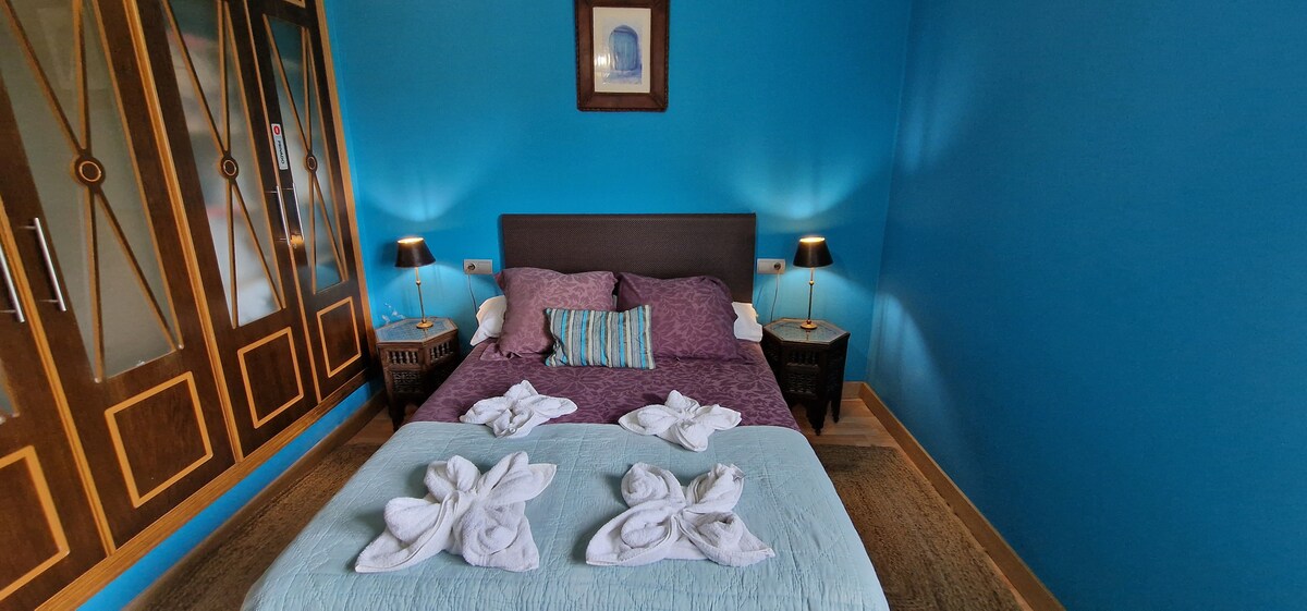 Dormitorio azul con personalidad y vistas al jardín