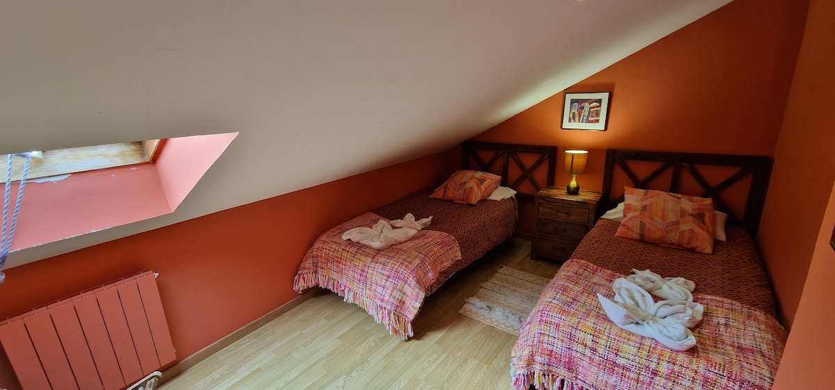 Dormitorio abuhardillado con dos camas individuales