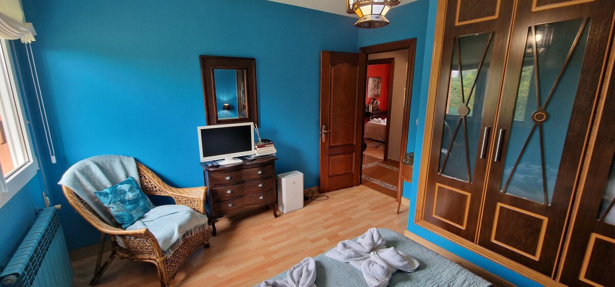 Dormitorio azul con personalidad y vistas al jardín