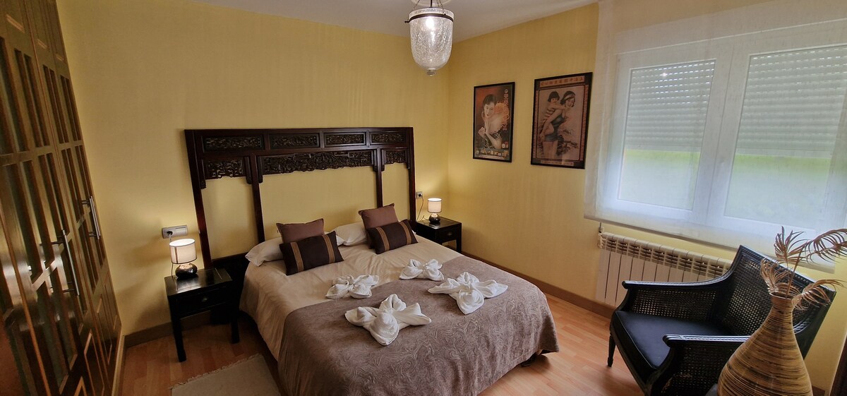 Dormitorio principal con baño y zona de descanso