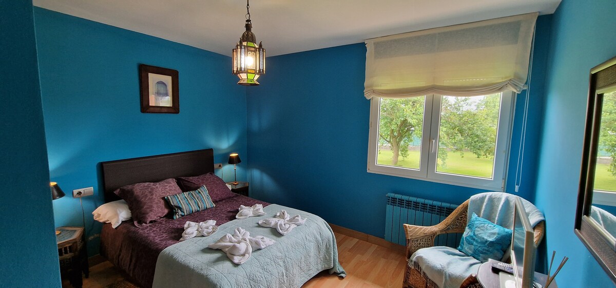 Dormitorio azul con personalidad y vistas al jardín